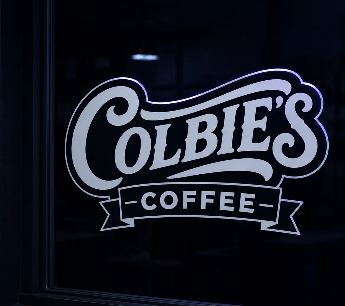 A cut-vinyl wordmark on a storefront window at night